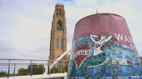 Boston Buoy decorated with mermaid and mosaic of tiles with Boston's St Botolph's Church in the background