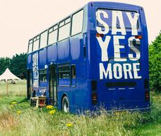 converted bus with the text 'Say Yes More' on the back