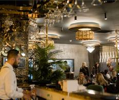 restaurant interior with large ferns and gold lighting