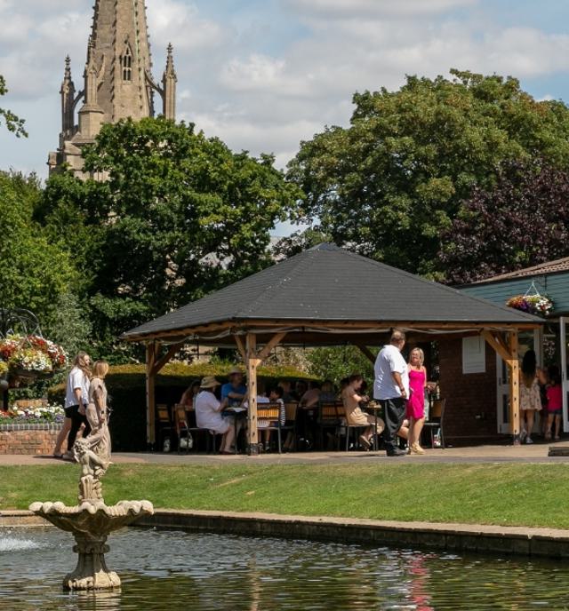 pond, water feature and church with people walking around sunny day